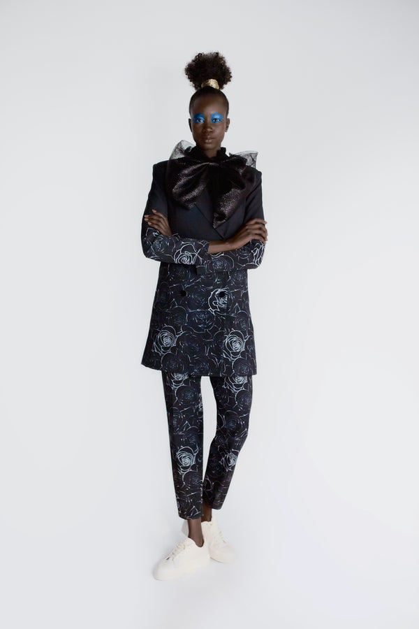 Model wearing black floral print relaxed cropped trousers