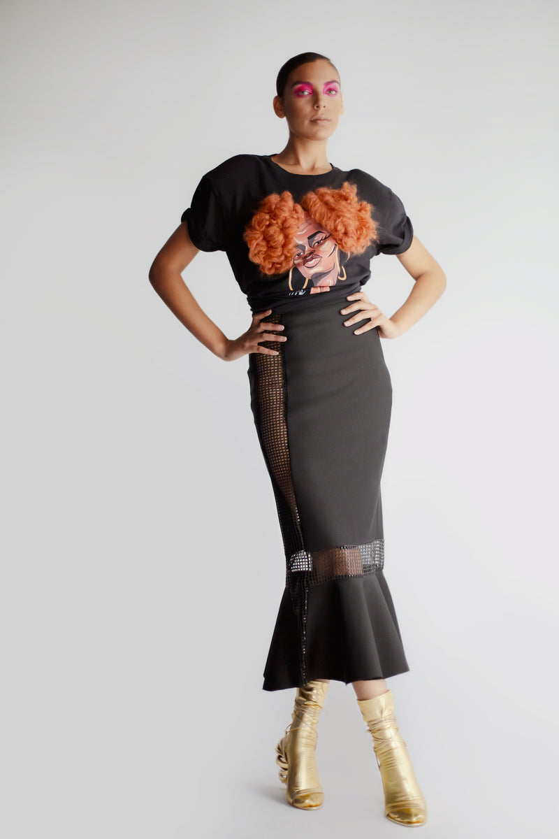 Model wearing black midi length skirt with sheer panels and fishtail