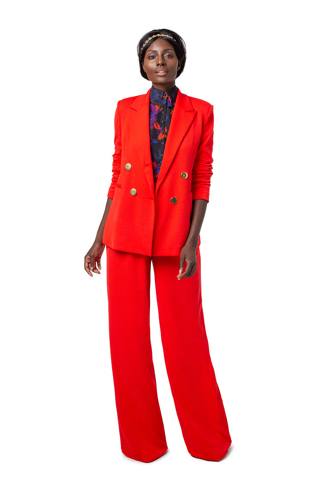 Front of model wearing red Ebi double breasted jacket with gold buttons